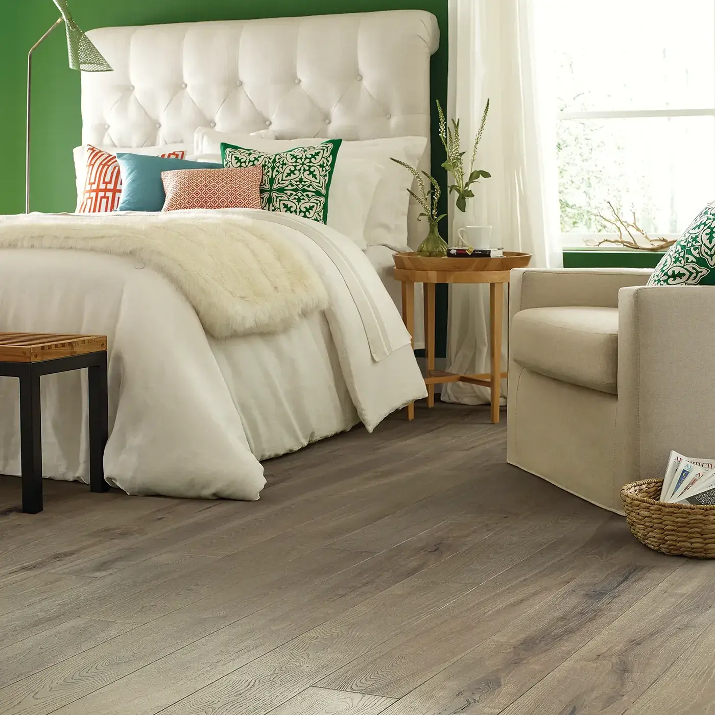 Gray-toned hardwood in a bedroom with a white tufted headboard | FloorCo.