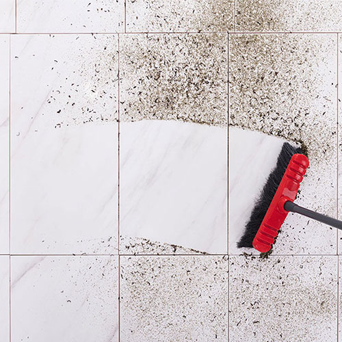 Broom sweeping away dirt on a tile floor | Floorco Premium