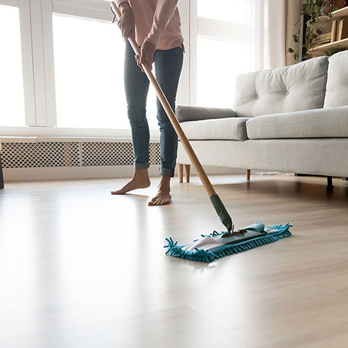 person sweeping laminate flooring | Floorco Premium
