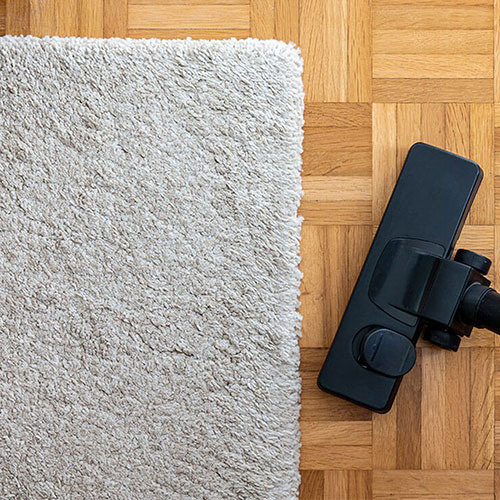 Vacuum next to area rug | Floorco Premium